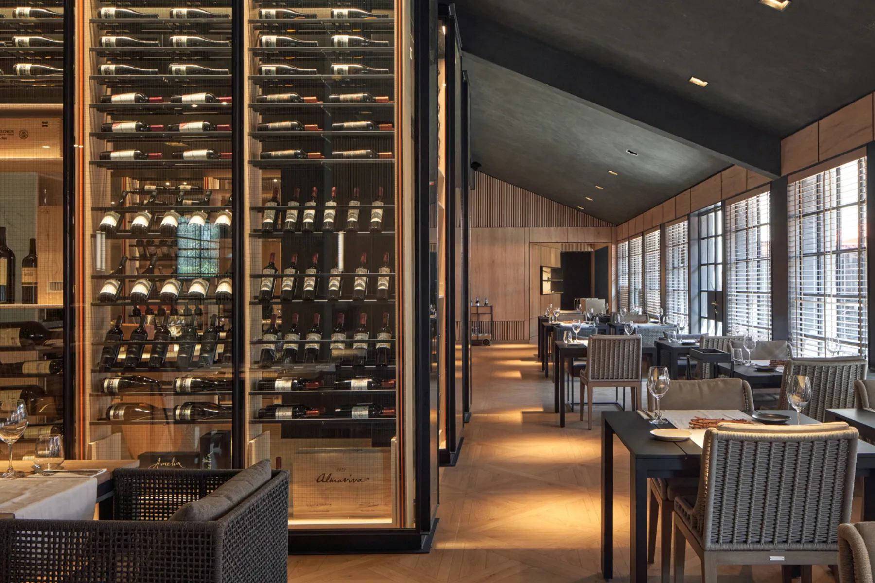 Comedor del Restaurante Bodega 1883 con cava de vinos y vista al viñedo