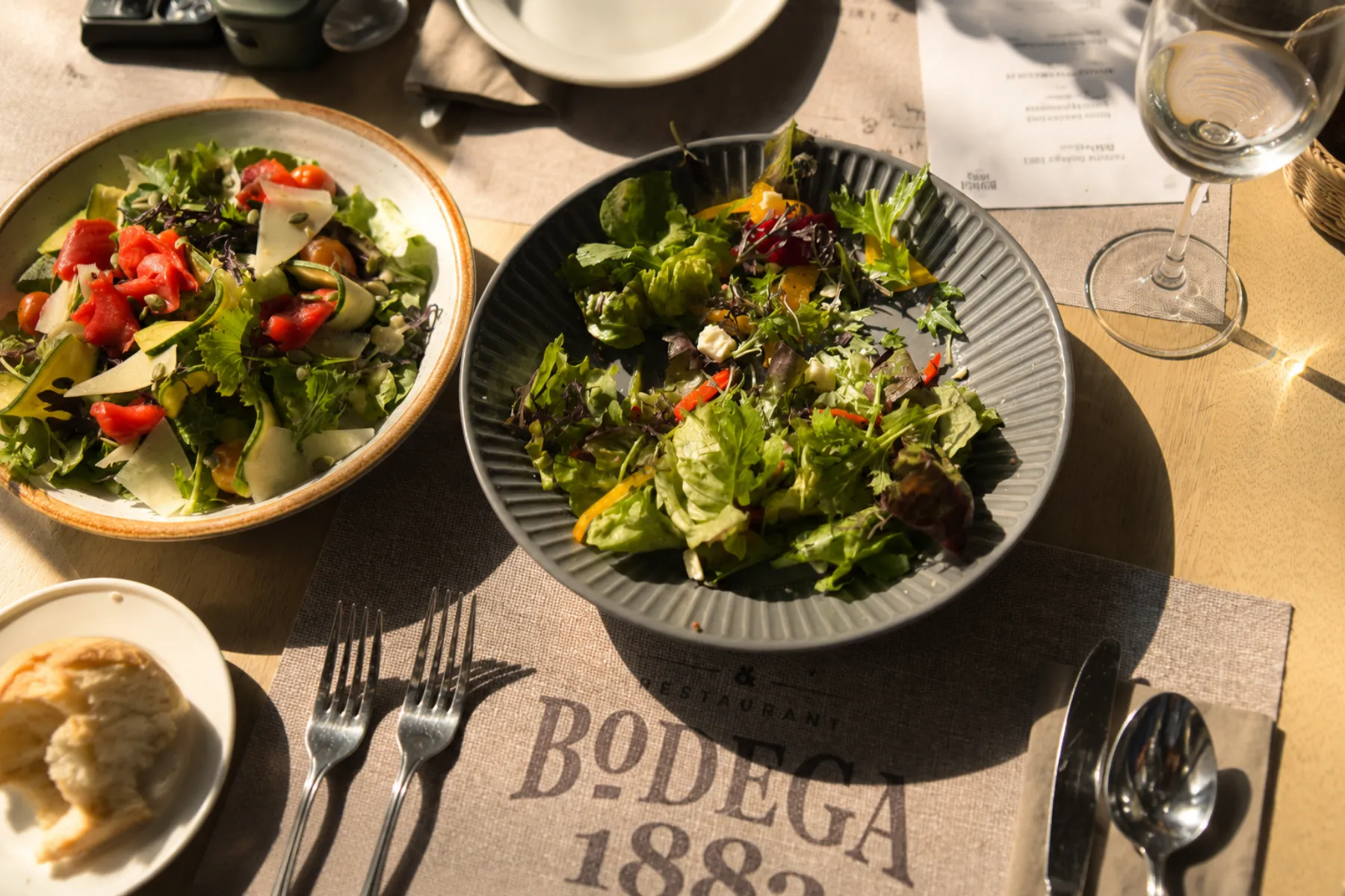 Ensaladas servidas sobre individual Bodega 1883